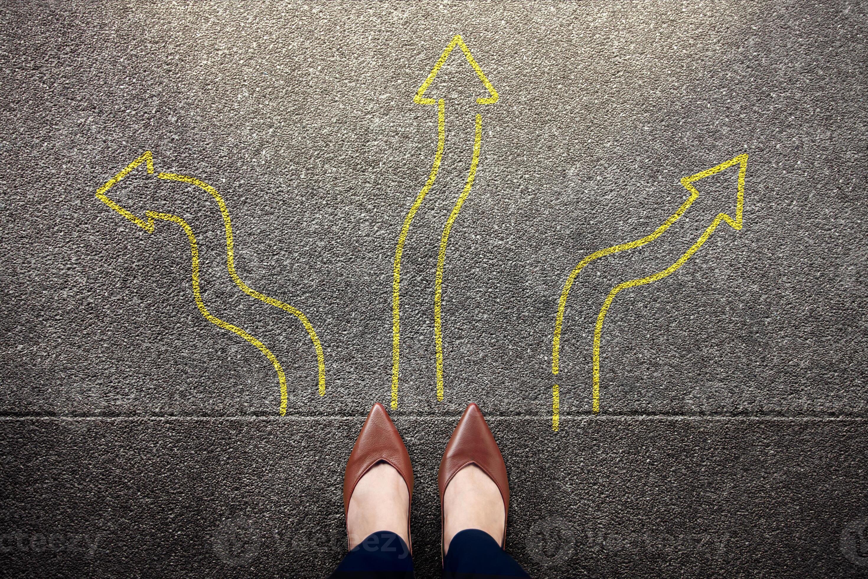 feet-standing-among-many-drawn-arrows-symbolizing-decision-photo